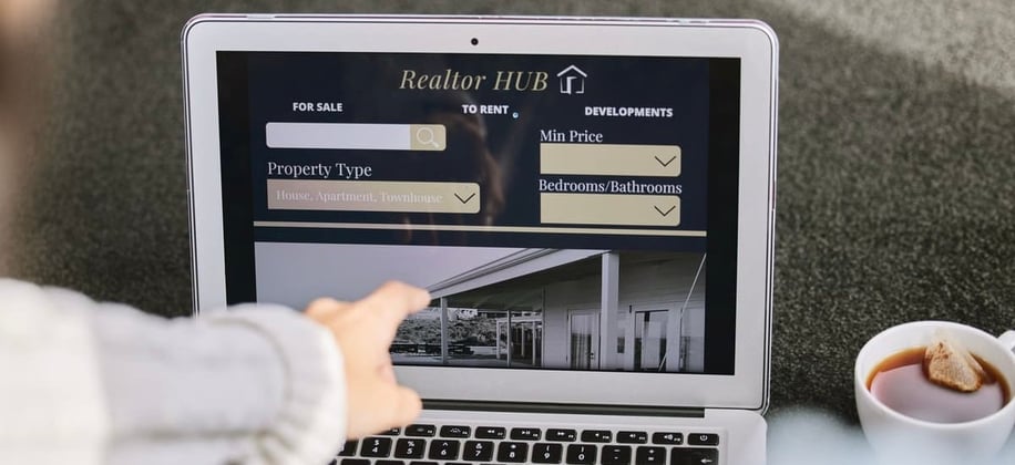 A woman looking at an online property listing on a laptop