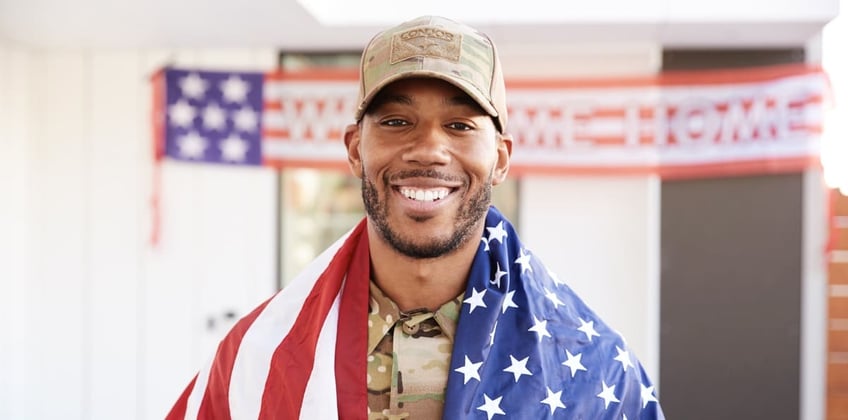 A veteran with an American flag around him
