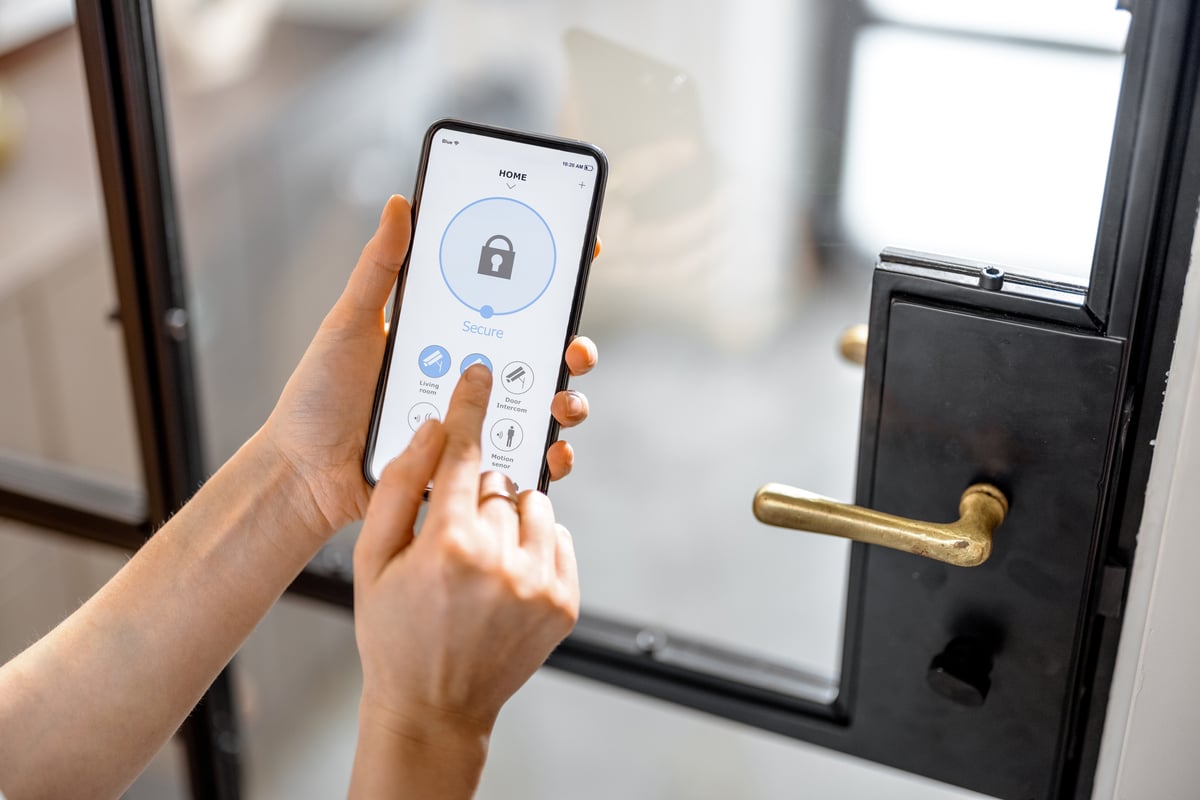 A close-up of hands locking the door with a phone