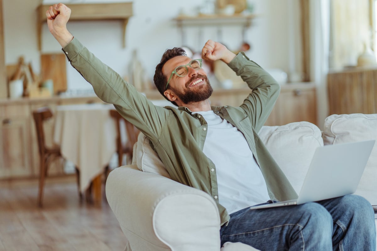 A happy man stretching on the couch