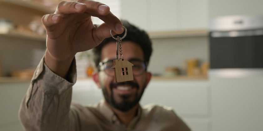 A man holding house keys inside his home
