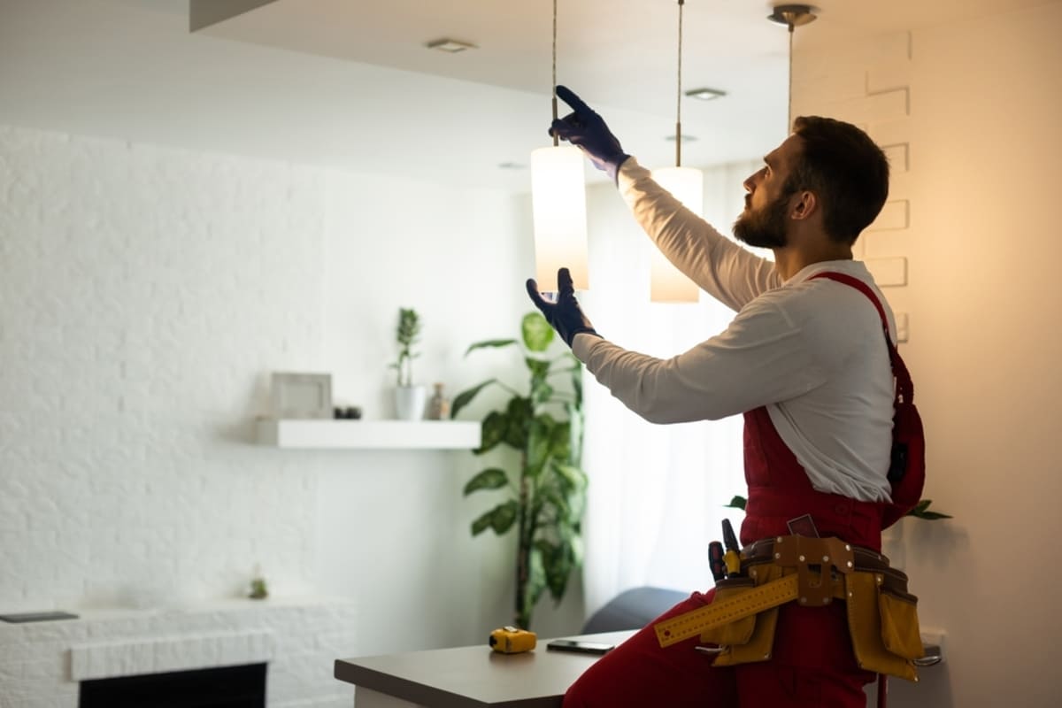 A man installing lightbulbs in a ceiling light, RPA property maintenance concept