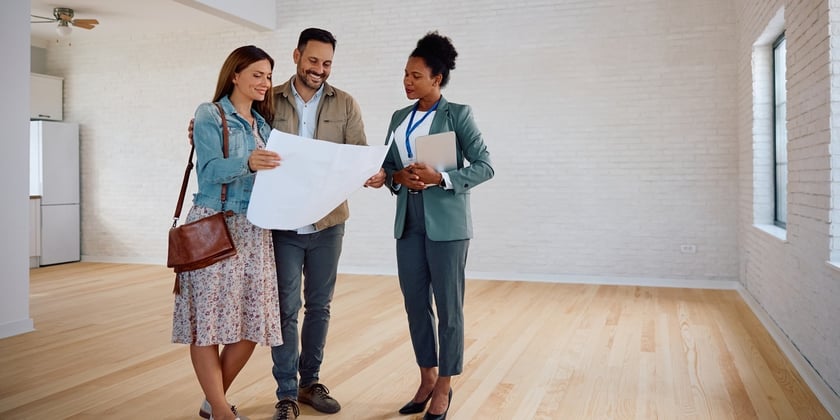 A real estate agent giving two people a tour of home