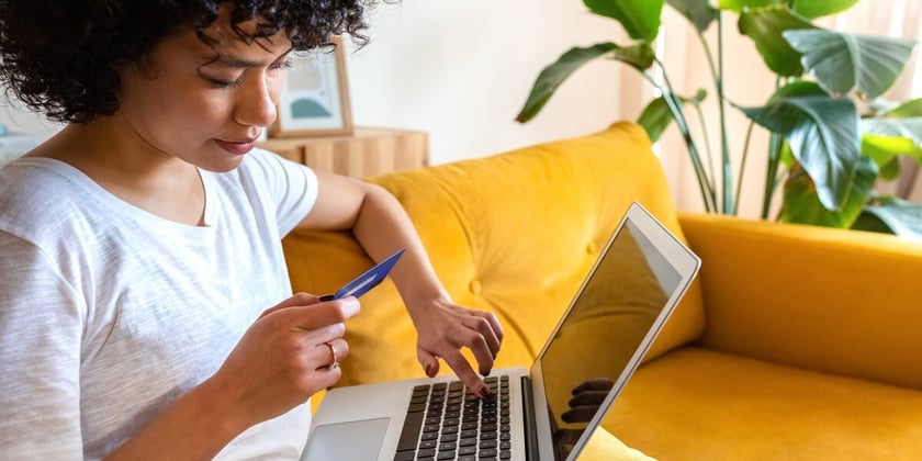 A woman putting her card info into her laptop