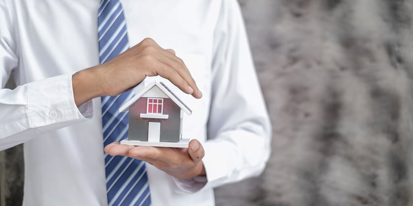 Property manager holding a house model