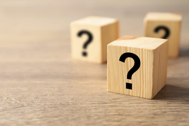 Question marks on wooden blocks, choosing property management vs self management concept