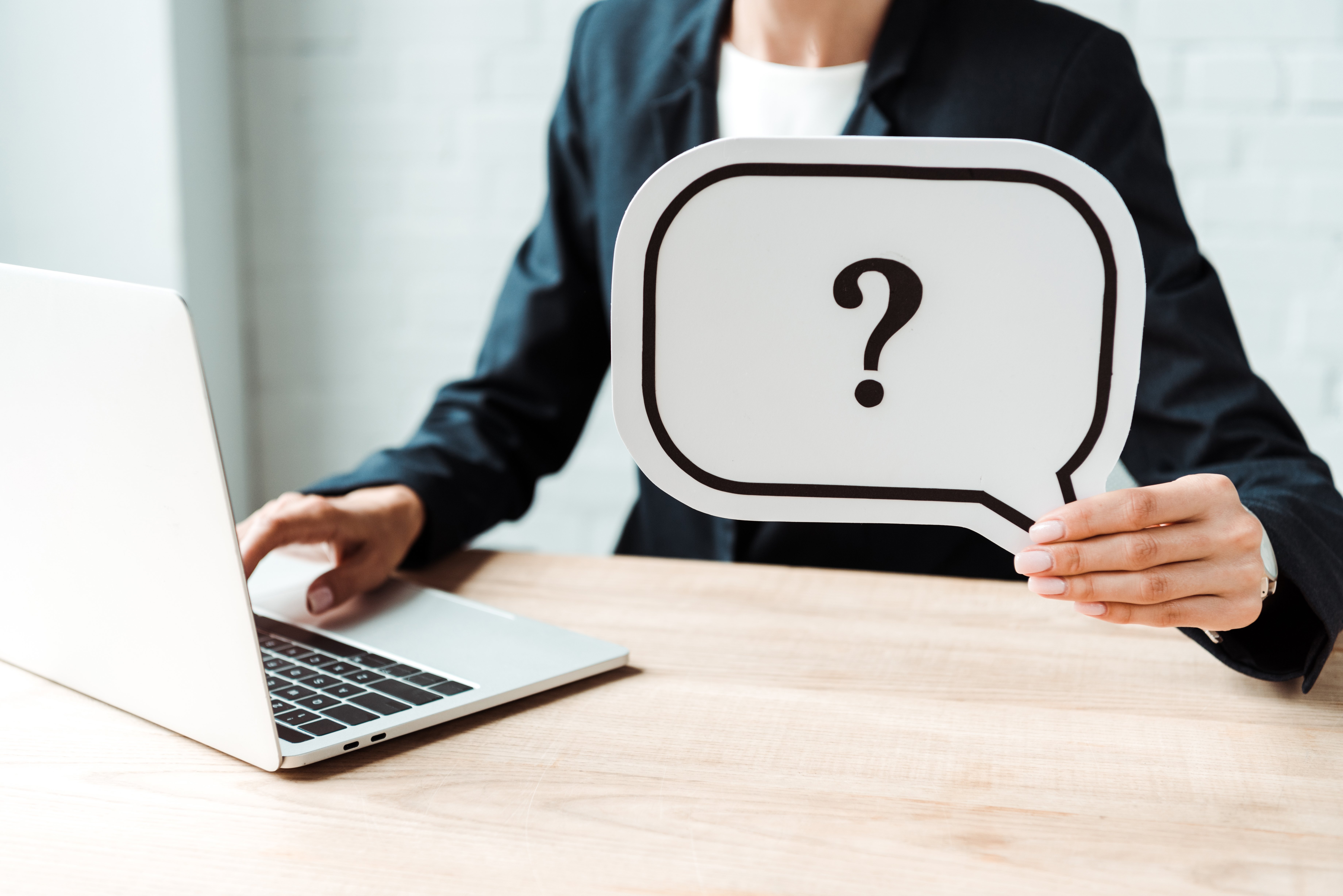 Woman holding speech bubble with question mark