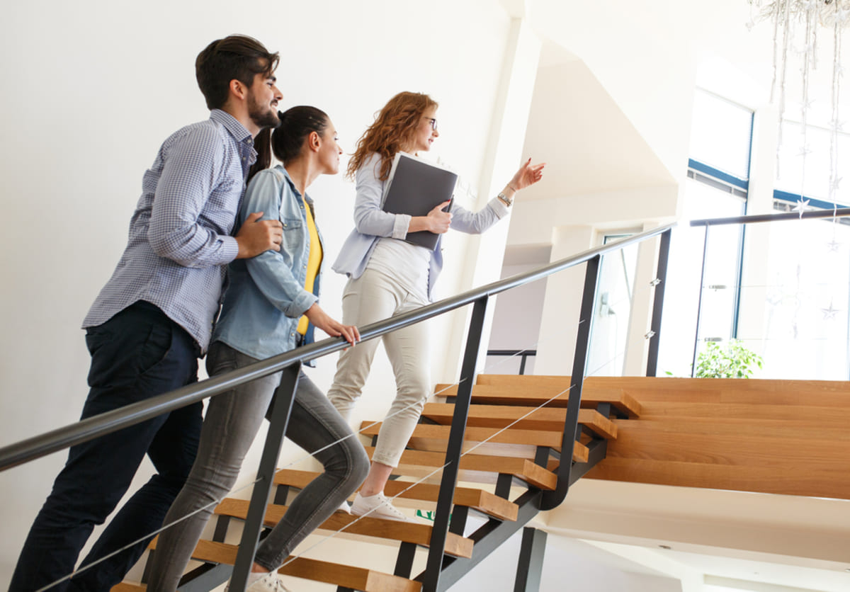 Woman showing a home to a couple representing professional Seattle property management