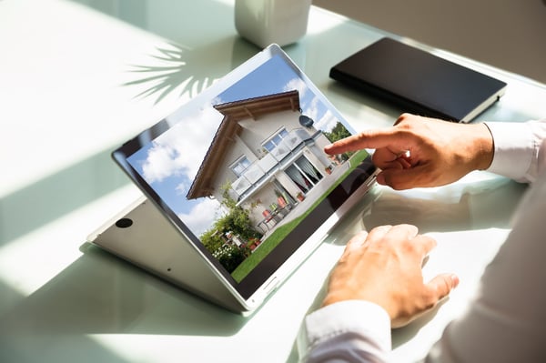 Close-up of businessman's hand checking house on laptop
