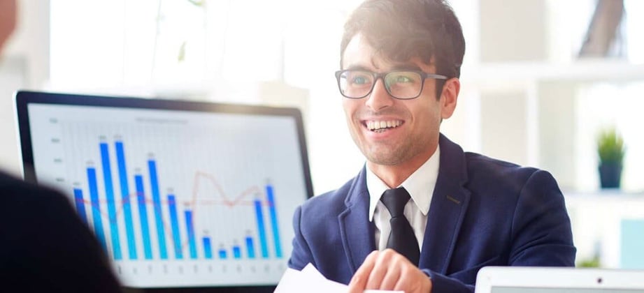 Two men having a meeting next to charts and graphs