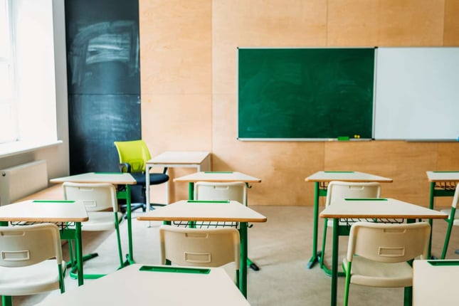 Interior of empty modern classroom with blank chalkboard at school (R) (S)