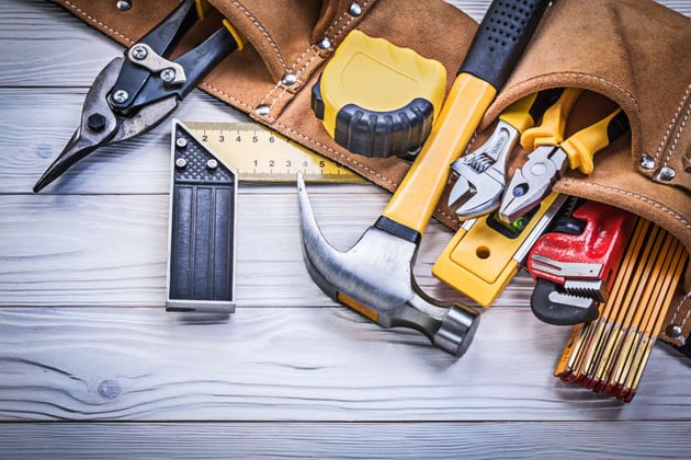A tool belt with tools for rental property maintenance