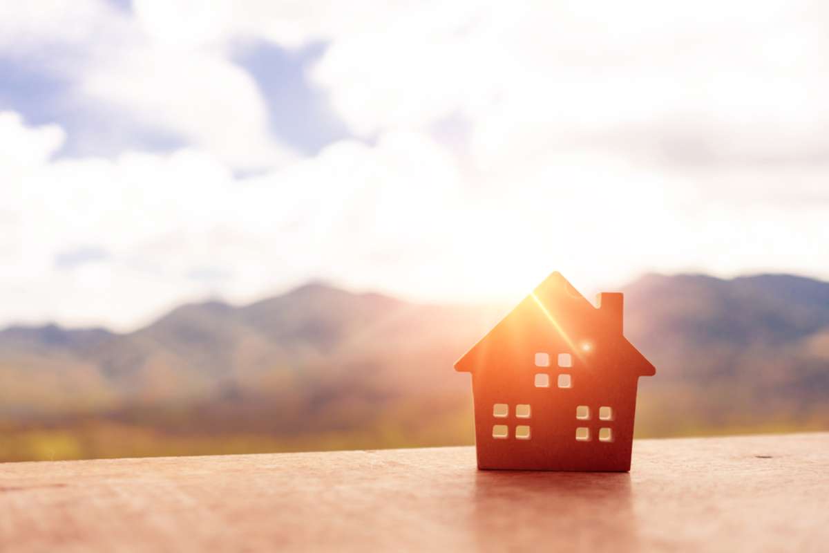 Closed up tiny house model on the wooden floor or board with light green background