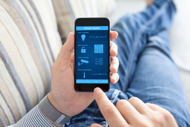 Man holding phone with smart home on screen