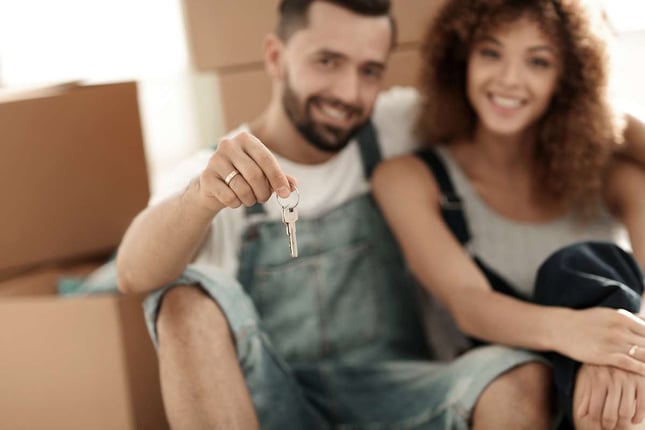 Smiling couple on the background of large cardboard boxes