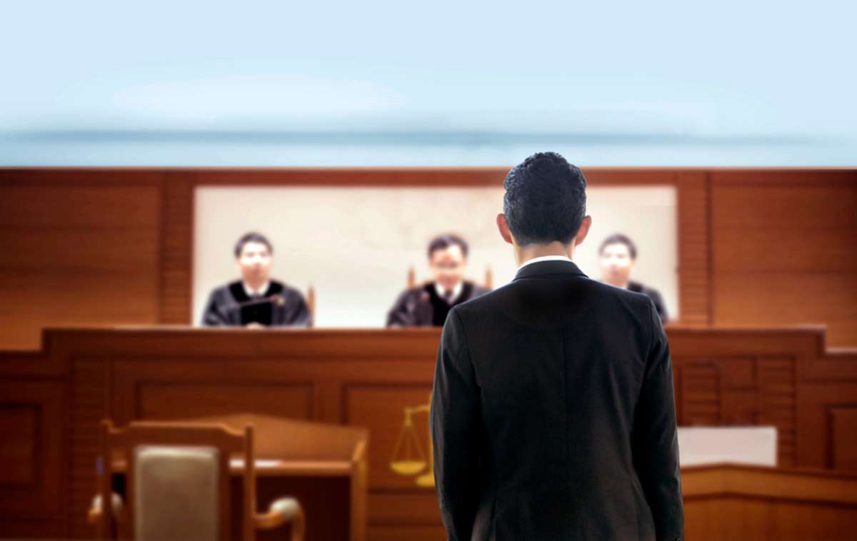 back of lawyer talking to attorney in courtroom