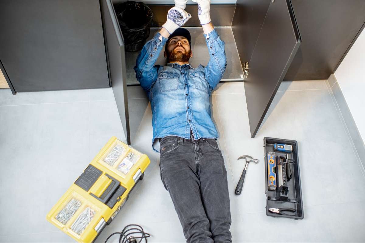 man repairing kitchen plumbing