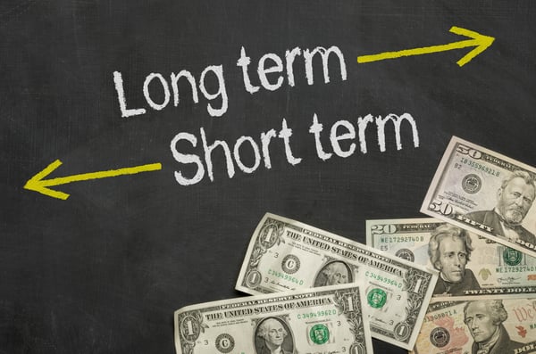 Text on blackboard with money - Long term and short term