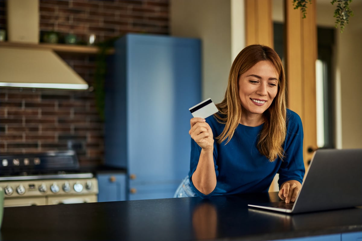 Woman Smiling with Laptop and Credit Card