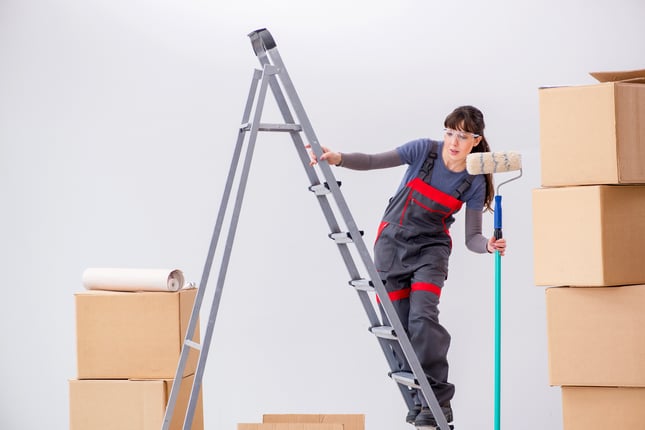 Woman painter painting in new apartment