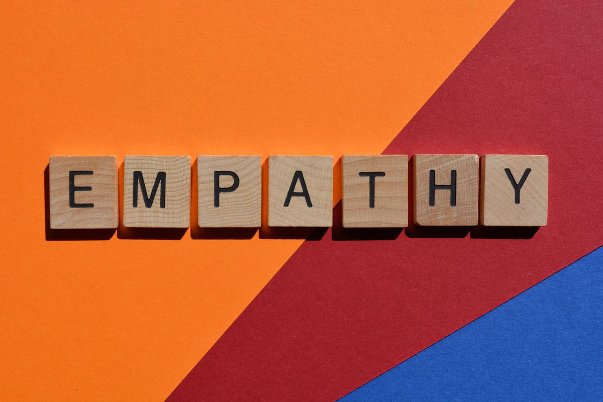 Wooden block letters spelling empathy on a colorful background