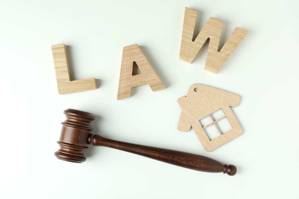 Wooden letters that spell law next to a wooden house and a gavel