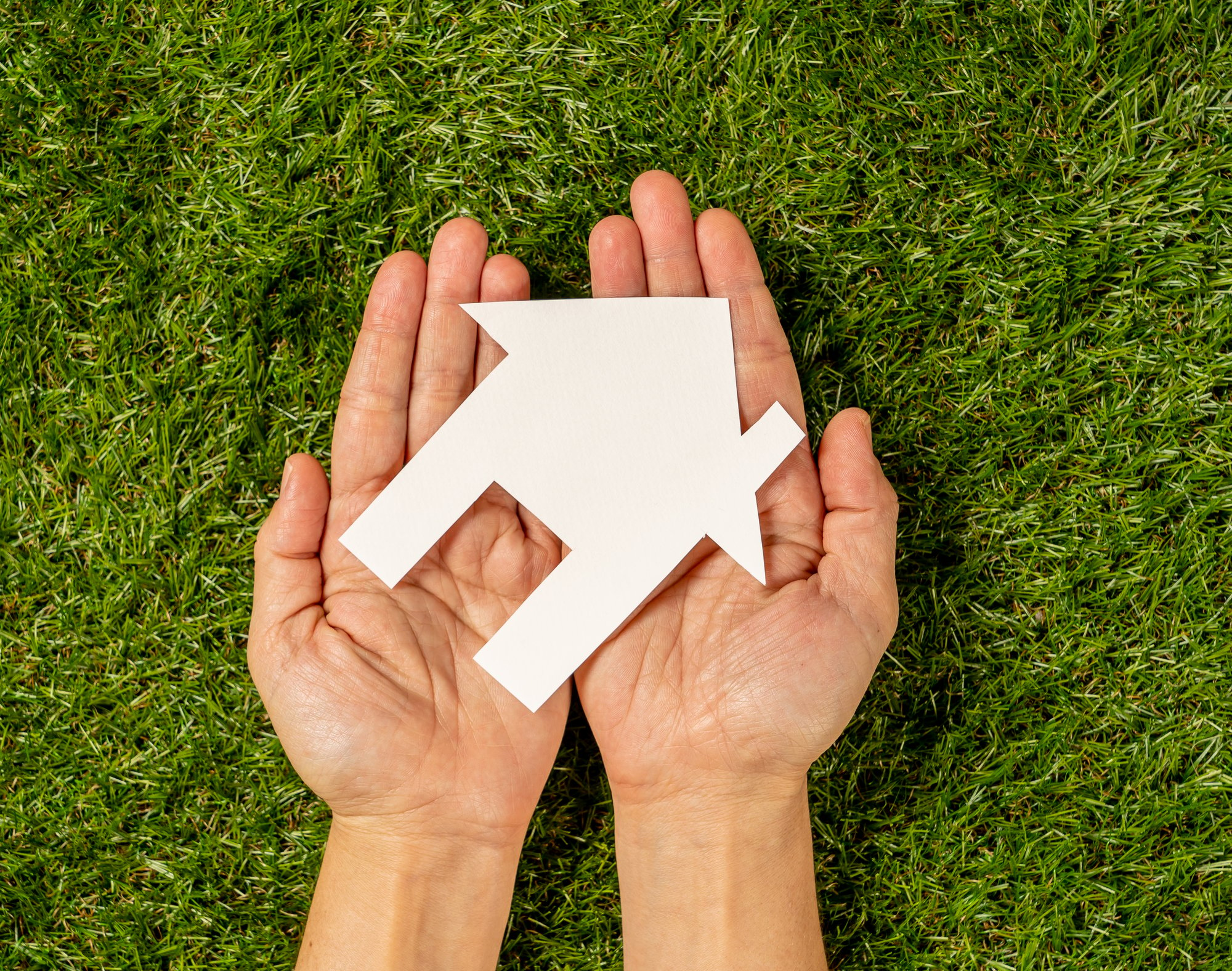 woman hands holding white house over green grass field in Property investment Real estate Saving and buying a home mortgage and loan banking