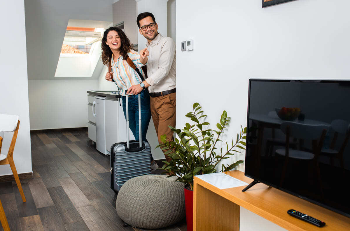 A couple entering a short-term rental property with suitcases