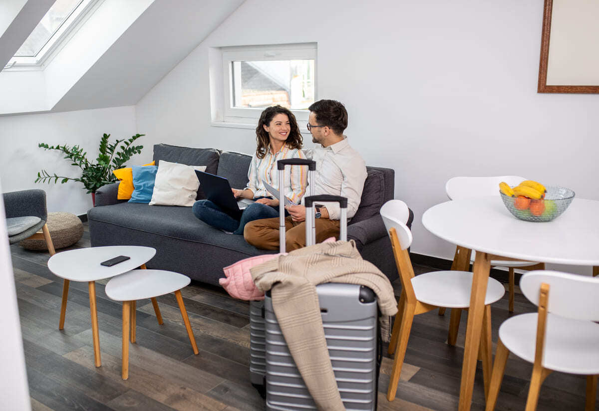 A couple smiling sitting on a couch in an airbnb