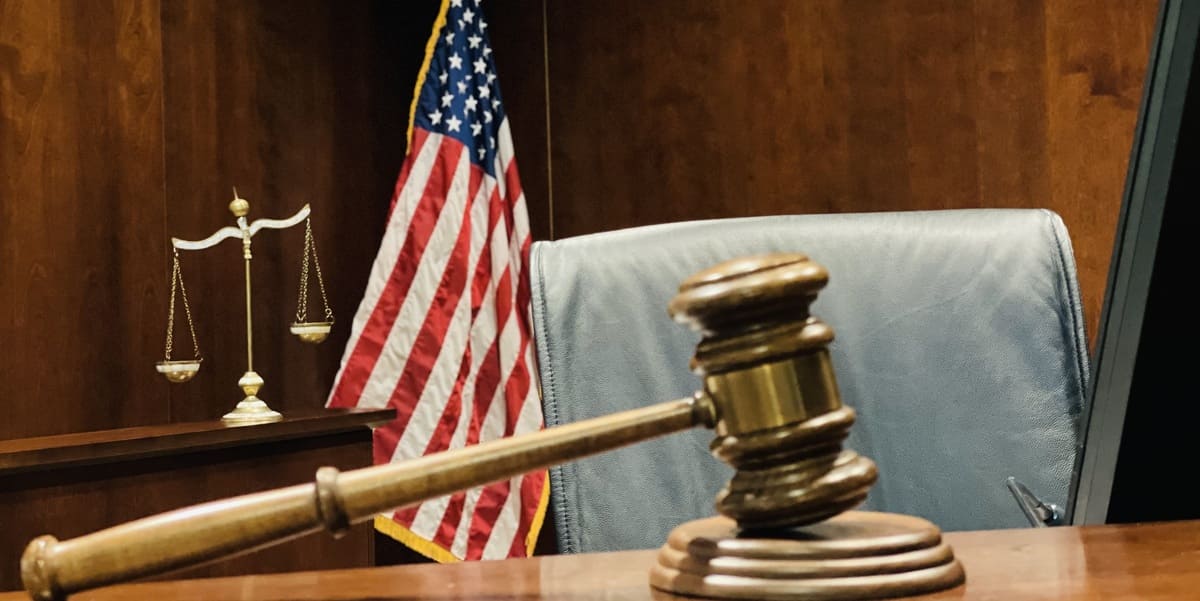 A gavel and American flag in a court room