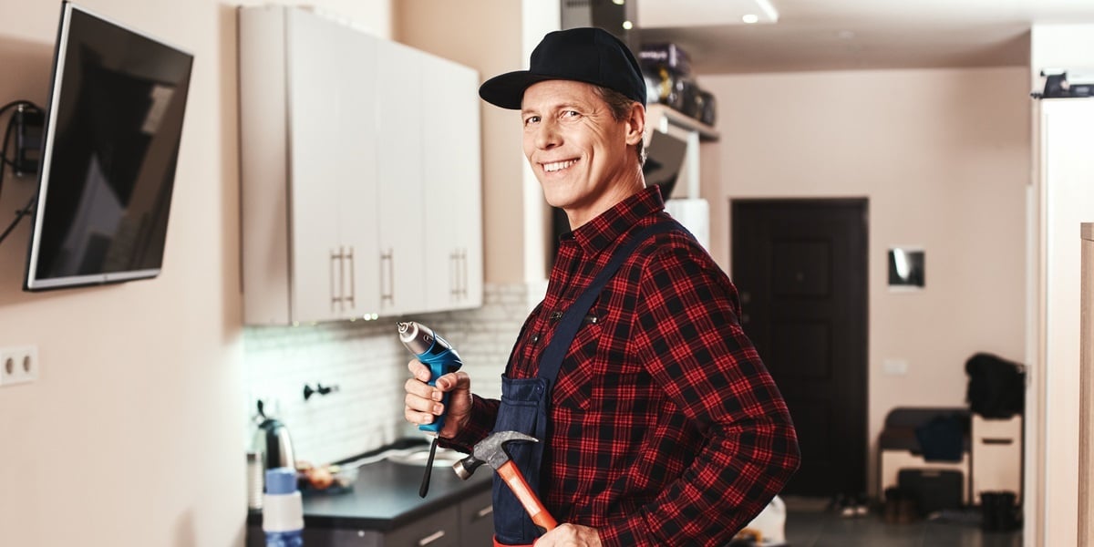 A contractor with maintenance tools inside a home