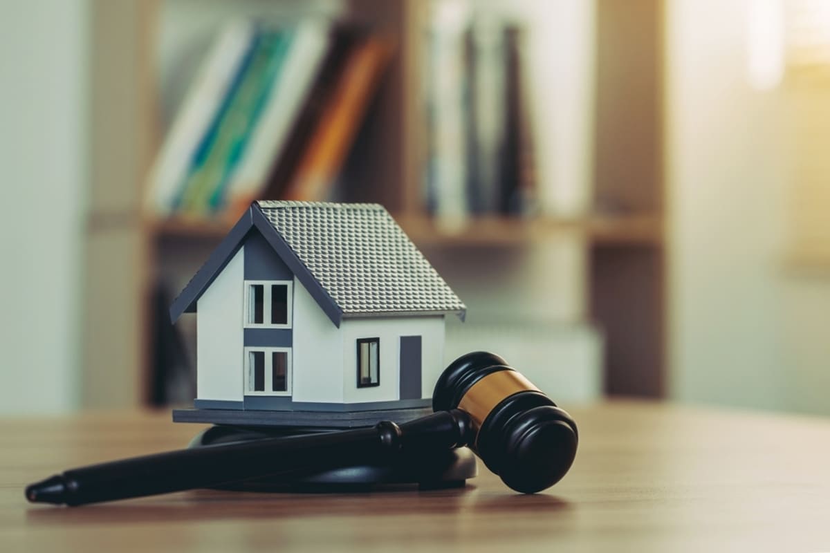 A gavel next to a small house, Seattle rental laws concept. 