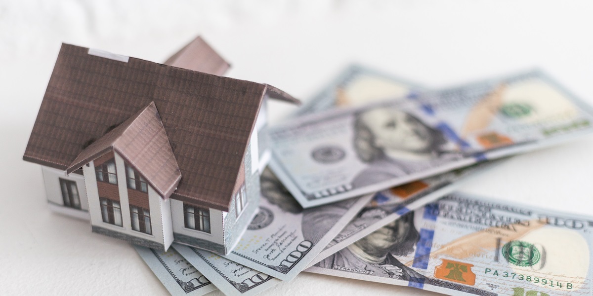 Pile of money bedise a house model showing concept of move in fees