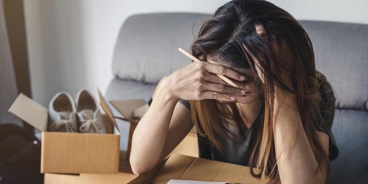 Sad female packing boxes to move out  of her rental apartment
