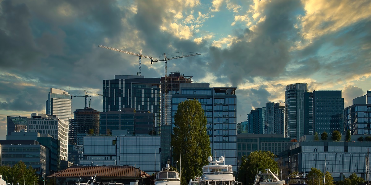 Seattle city with high glass buildings and boats in the harbor