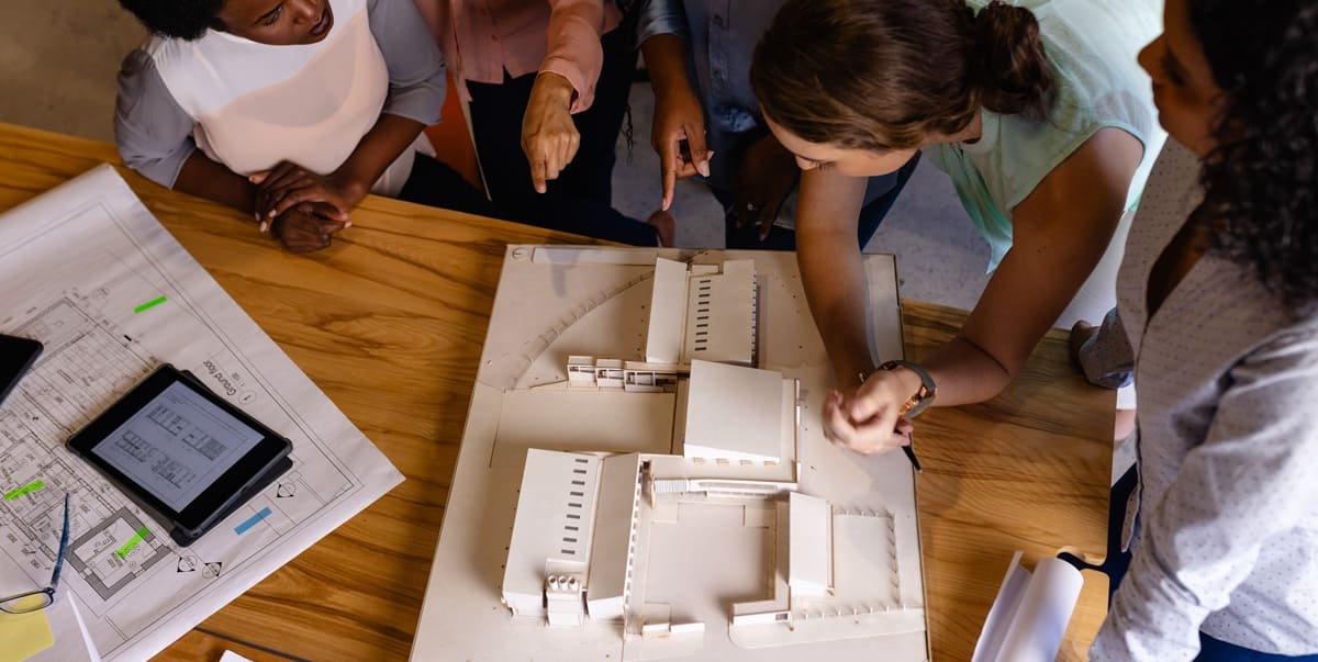 architects in discussion using model and blueprints