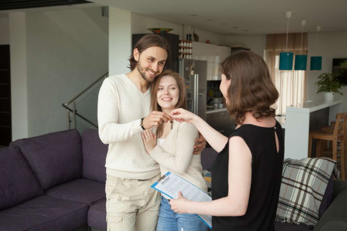 Happy young couple getting keys to their new home